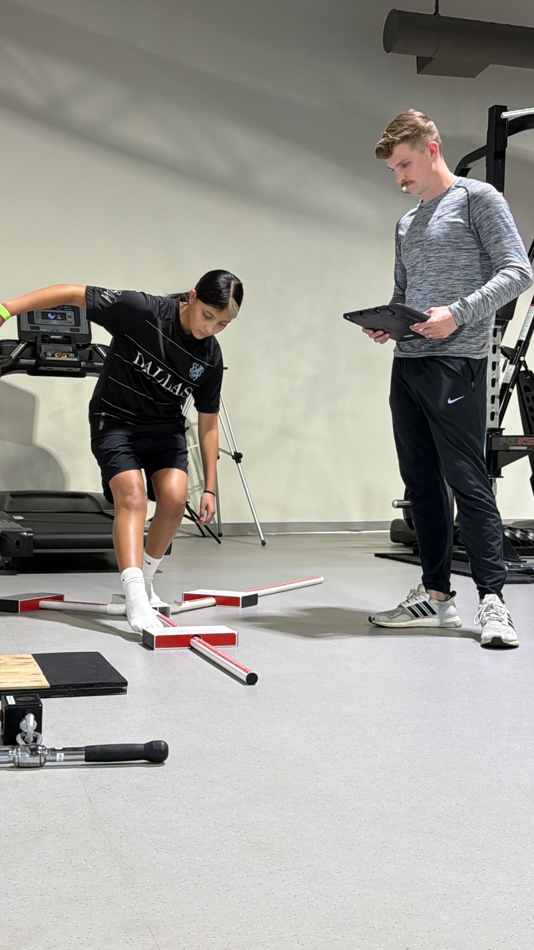 Jaylei working through a hurdle and balance drill while a clinician records data